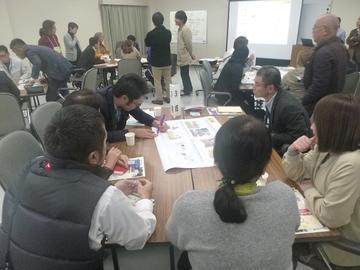 テーブルに資料が置かれ、6人で話をされている写真