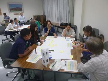 テーブルに3班と書かれた紙が置いてあり、資料を見ながら話をしている5名の方の写真