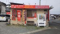 自動販売機とのぼり旗が3本ある店舗前を写した写真