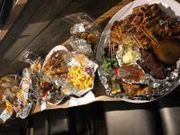 カウンターの上に並べられた様々な炭坊主の料理の写真
