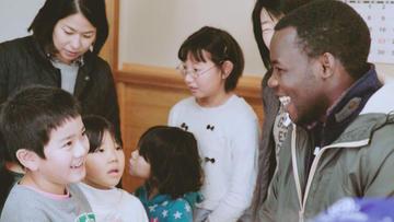 国際交流に参加している関係者と子供達を写した写真