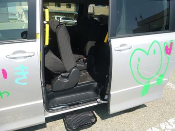シルバー色の車の後部座席のドアがあいており、座席が写っている写真