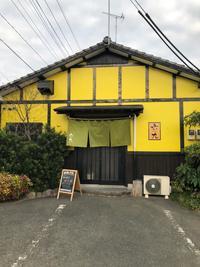 黄色の壁が印象的な六九の店舗入口を写した写真