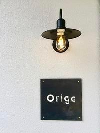 壁に電球の外灯と白字でOrigeと書いてある黒くて四角い表札の写真