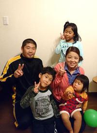 矢野さん家族5人がピースサインをして写っている写真