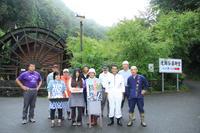 水車小屋の前に並ぶ壮年会の11人の人達の集合写真