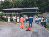 防災訓練で消防隊員の説明を聞いている参加者の人達の写真